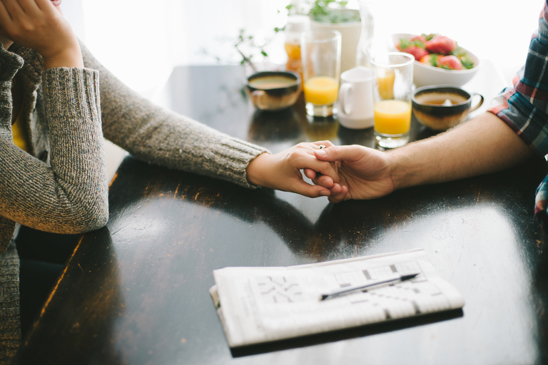 holding hands at the breakfast table